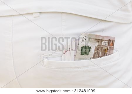 Close-up Bundle Of Banknotes In A Back Pocket Of White Pants