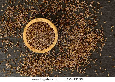 Lot Of Whole Dry Caraway Fruits In A Wooden Bowl Flatlay On Grey Stone