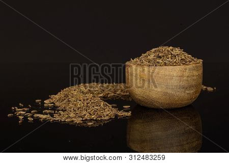 Lot Of Whole Dry Caraway Fruits In A Wooden Bowl Isolated On Black Glass
