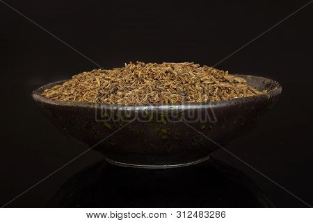Lot Of Whole Dry Caraway Fruits In A Grey Ceramic Bowl Isolated On Black Glass