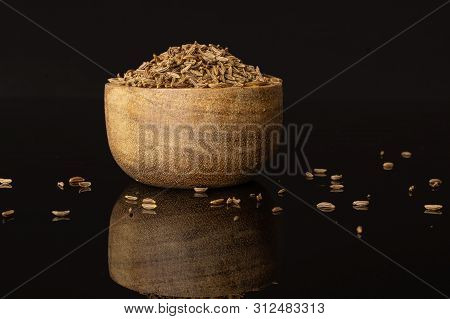 Lot Of Whole Dry Caraway Fruits In A Wooden Bowl Isolated On Black Glass