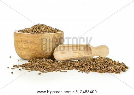 Lot Of Whole Small Dry Caraway Fruits In A Wooden Bowl With Wooden Scoop Isolated On White Backgroun