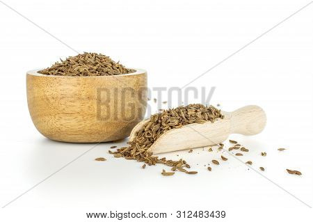 Lot Of Whole Small Dry Caraway Fruits In A Wooden Bowl With Wooden Scoop Isolated On White Backgroun