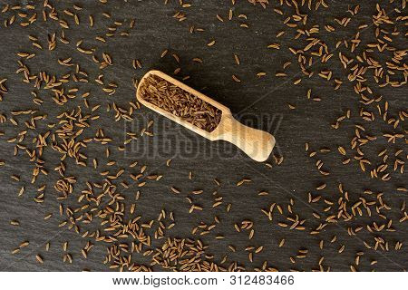 Lot Of Whole Dry Caraway Fruits With Wooden Scoop Flatlay On Grey Stone