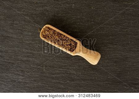 Lot Of Whole Dry Caraway Fruits Closeup With Wooden Scoop Flatlay On Grey Stone