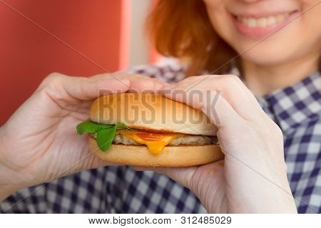 Young Girl Holding In Her Hands, Fast Food Burger With Fresh Vegetables,  Beef,  Lettuce, Cheese And