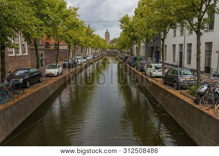 Delft, The Netherlands - July 19 2019 : View Of Historic Oude Canal Leading To  View Of The  Oude Ke