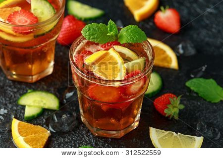 Refreshing Pimms Cocktail With Fruit And Vegetables On Rustic Black Table