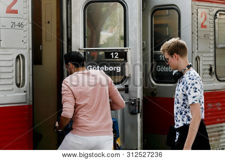 Karlstad, Sweden - July 12, 2019: Two Passengers Boarding A Train Operated By Tagab With Destination