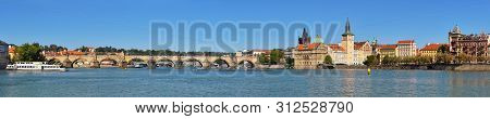 Autumn Panorama Of Charles Bridge And Historic Buildings On The Riverside In Prague Captured From St