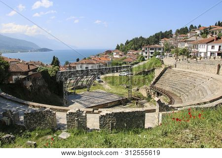 Antique Ancient Roman Amphitheater Or Antique Theatre Of Ohrid With View On Old Town Of Ohrid And La