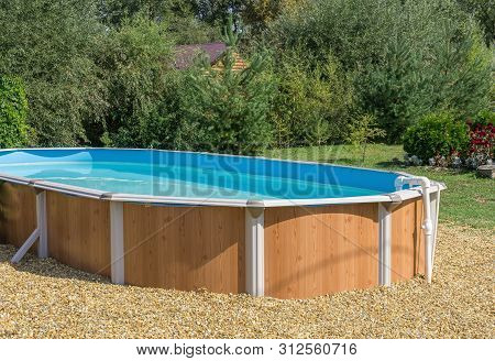 Prefab Pool With Thermal Water Is On Lawn Near Forest. Sunny Day
