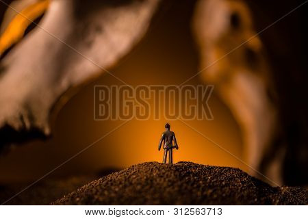 Artwork Decoration With Animal Bone. Silhouette In An Underground Abandoned Crypt. Man Standing In F