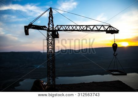 Abstract Industrial Background With Construction Crane Silhouette Over Amazing Sunset Sky. Tower Cra