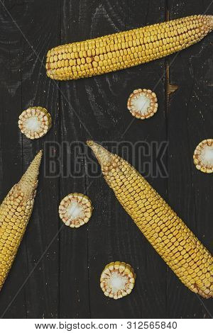 Shucked And Cleaned Sweet Corn On Black Wood Background. Sweet Corn Cut On Desk.