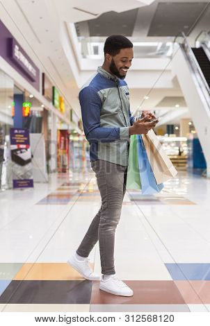 Smiling African American Guy With Cellphone Whriting Good Rewiew On Shop Online, Free Space