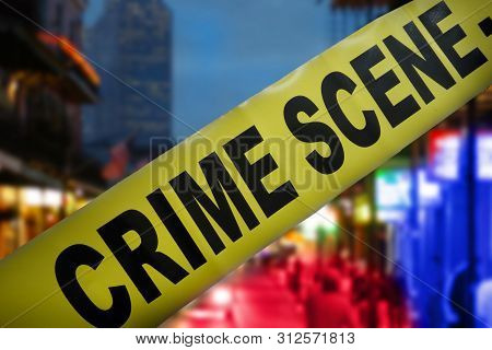 Yellow Police Crime Scene Tape With Night Time City Street In Background