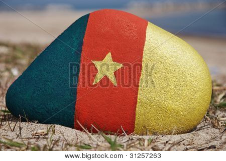 cameroun flag colours on a stone on the beach