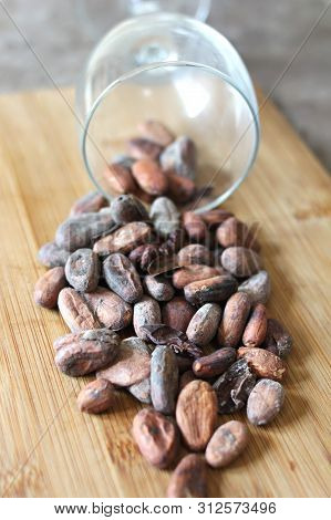 Cocoa Beans Spilling From A Glass Onto A Wooden Surface, Vegan Food, Igridient For Healthy Sweets, E