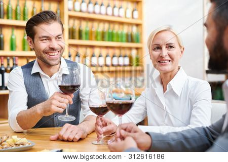 Meeting of successful cavists discussing new sorts of drinks by table