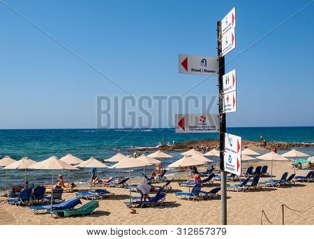 Malia, Crete, Greece - Juni 18, 2019: People Are Resting On A Sunny Day At The Beach In Malia, Crete