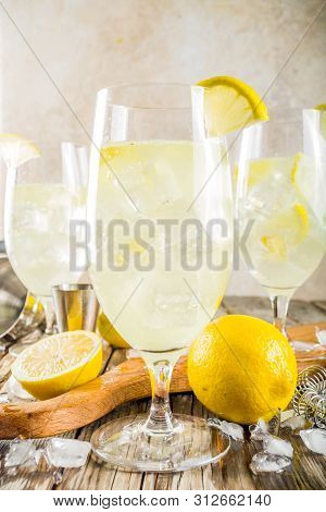 Trendy Summer Cold Drink. St Germain French Spritz Cocktail With Lemon Slices, Old Rustic Wooden Bac