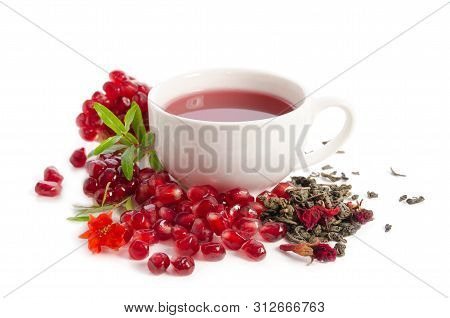 Parts Of A Pomegranate With Pomegranate Seeds And Leaves, Flowers, Dry Tea Of Carcade And Full Cup O