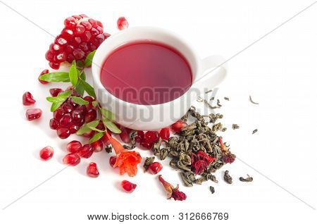 Parts Of A Pomegranate With Pomegranate Seeds And Leaves, Flowers, Dry Tea Of Carcade And Full Cup O