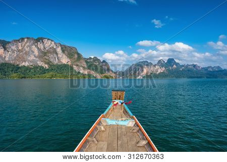 Wooden traditional thai longtail boat on Cheow Lan lake in Khao Sok National Park, Thailand