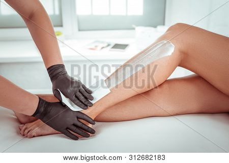 Diligent Professional Beauty Salon Worker Attaching Waxing Strips
