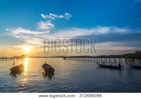 Beachside Sunset With Beautiful Boat, Bridge And Cloudy Sky