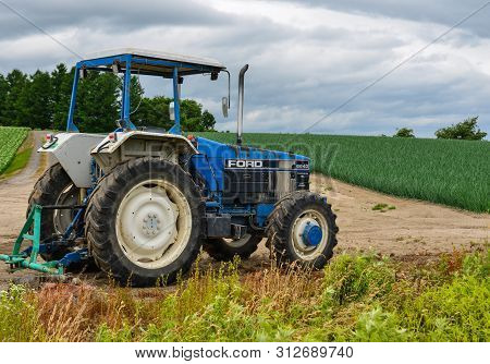 Furano, Japan - Jul 1, 2019. A Tractor Standing On The Field In Furano, Japan. Furano Located In The