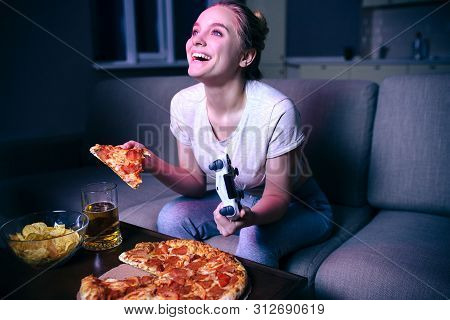 Young Woman Playing Game At Night. Happy Positive Model Look Up And Smile. Holding Gamepad And Slice