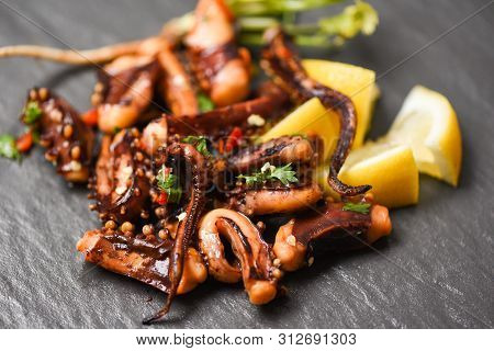 Octopus Salad With Lemon Herbs And Spices On Dark Background Top View / Tentacles Squid Grilled Appe