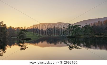 Stunning Landscape Image Of Tarn Hows In Lake District During Beautiful Autumn Fall Evening Sunset W