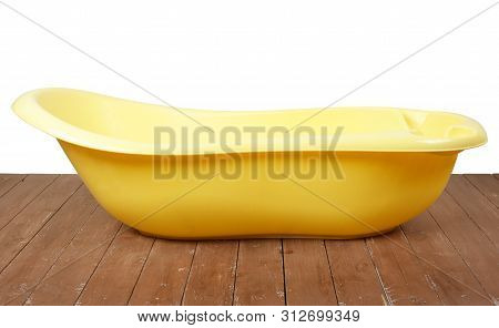 Motherhood  And Hygiene - Yellow Children Bath On A White And Wooden Background