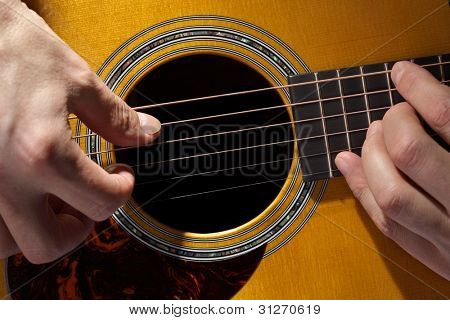 Akoestische gitarist spelen gitaar close-up op toets en soundhole