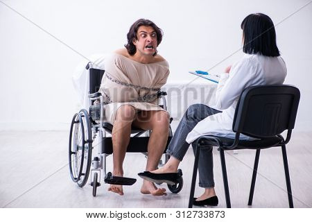 Old female psychiatrist visiting young male patient 
