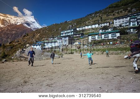 Namche Bazaar, Nepal - October 17, 2015: Unknown Children Playing Football On Dusty Playground, Namc