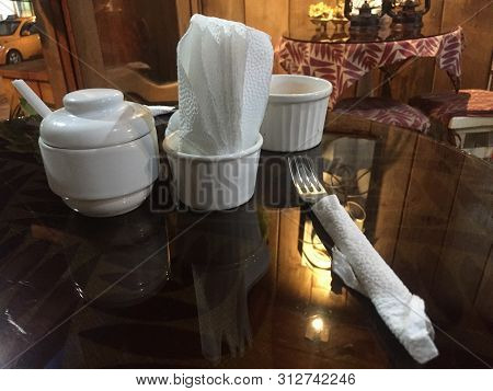 A Dinner Table In A Restaurant With Napkins, Salt And Cuttelry
