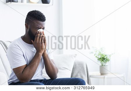 Young Sick African-american Man Cleaning Snotty Nose, Infected By Winter Grippe Virus Or Influenza, 