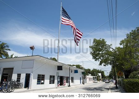 The View Of Truman Avenue With A Big Flag In Key West Town (florida).