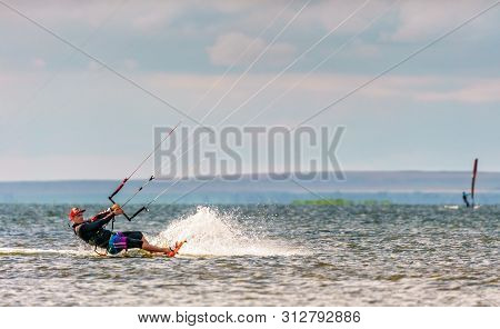 Anapa, Russia - July 9, 2017: Man Kitesurfer Rides Kite Splashing On Flat Surface Of Bugaz Firth At 