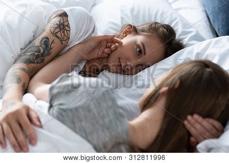 Selective Focus Of Two Lesbians Looking At Each Other While Lying In Bed
