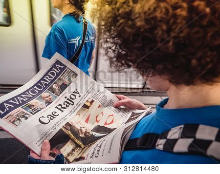 Barcelona - June 1 2018: Woman Carefully Reading In Barcelona Metro Station The La Vanguardia Newspa