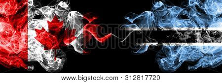 Canada Vs Botswana, Botswanan Smoky Mystic Flags Placed Side By Side. Thick Colored Silky Smoke Flag