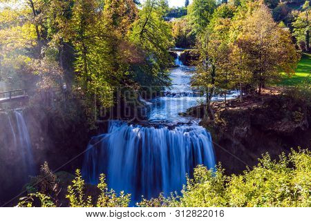 The small Croatian town of Slunj. Magnificent cascade of waterfalls on the Koran River. Magnificent dense forests surround the city and the river. The concept of ecological, active and photo tourism