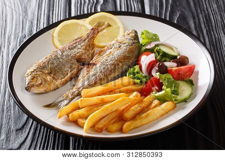Adriatic Fried Sarpa Salpa Fish With Lemon Served With Fresh Vegetable Salad And French Fries Close-