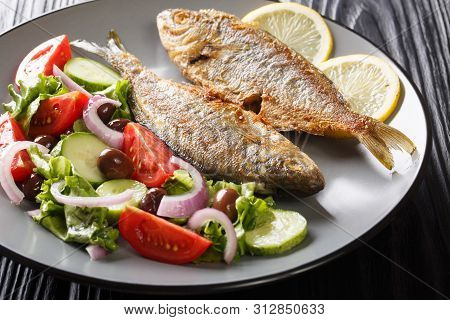 Spicy Fried Salema Porgy Sea Fish With Lemon And Fresh Vegetable Salad Close-up On A Plate. Horizont