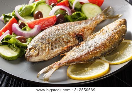 Fresh Fried Sarpa Salpa Fish With Summer Vegetable Salad  And Lemon Close-up On A Plate. Horizontal